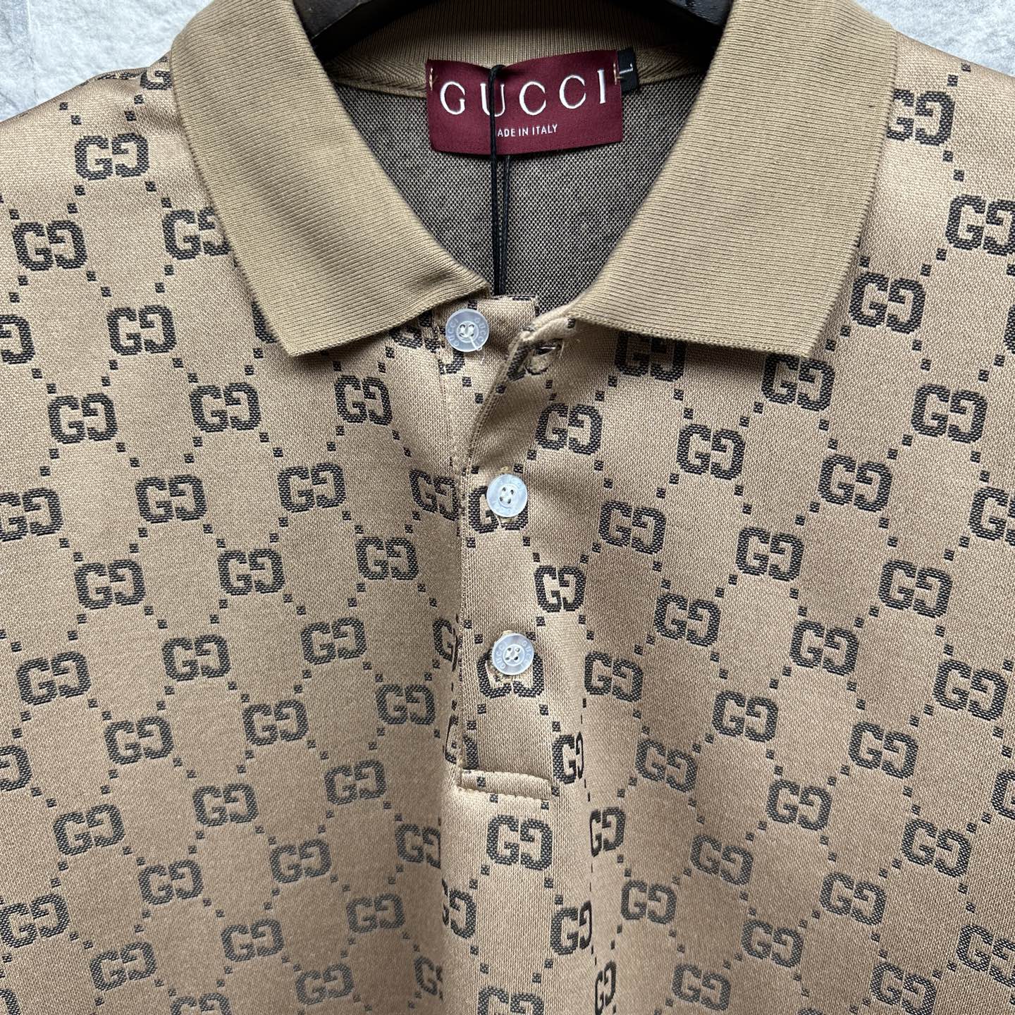 Beige GG monogram polo shirt with tan collar, button placket and Gucci label