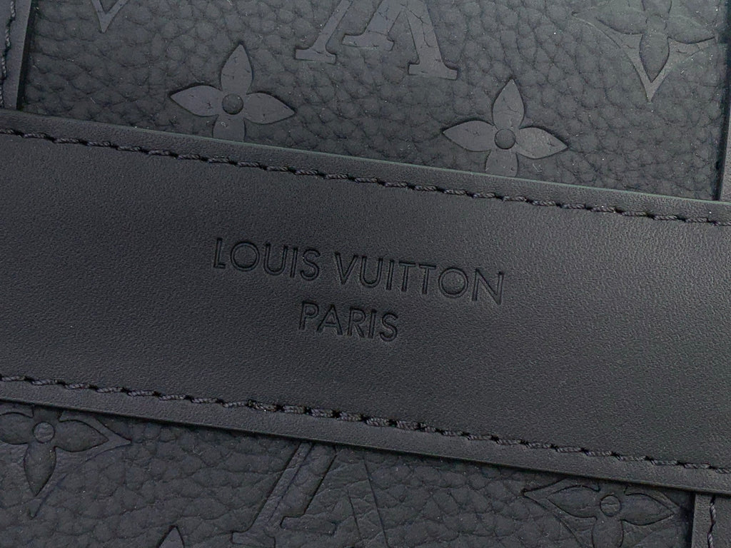 Louis Vuitton bag close-up of engraved “LOUIS VUITTON PARIS” logo on leather trim