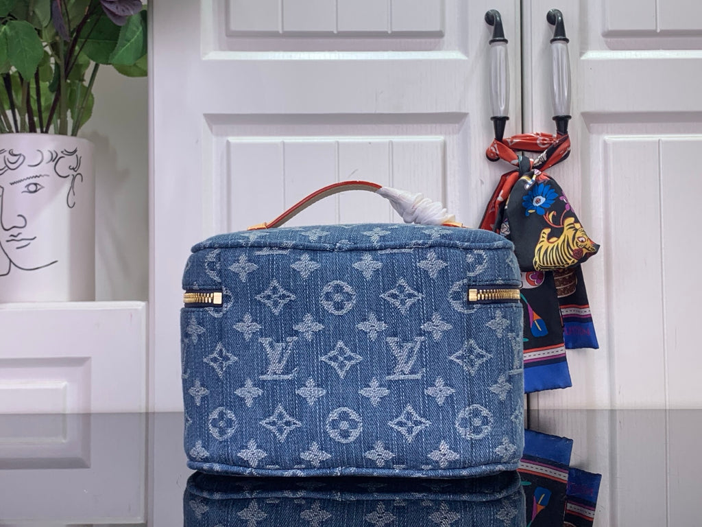 Blue monogram vanity bag with curved top handle, gold trim, front view.