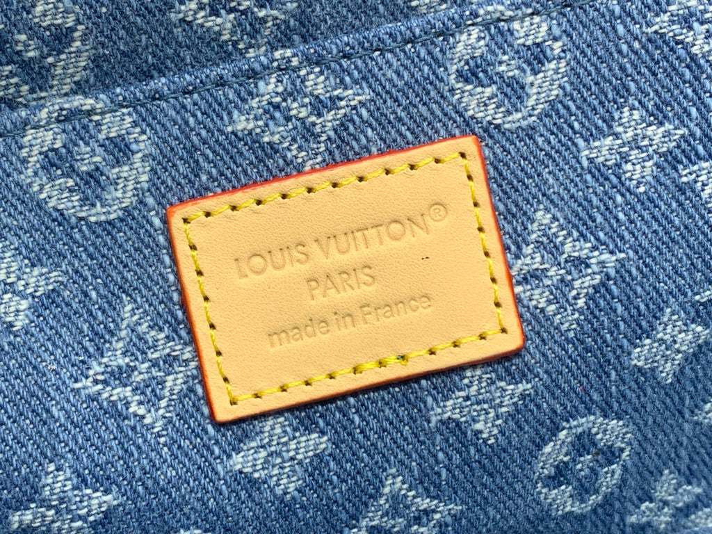 Tan leather brand patch on blue monogram bag: Louis Vuitton Paris, made in France.