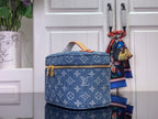 Louis Vuitton blue monogram canvas bag with gold zip top and tan leather handle