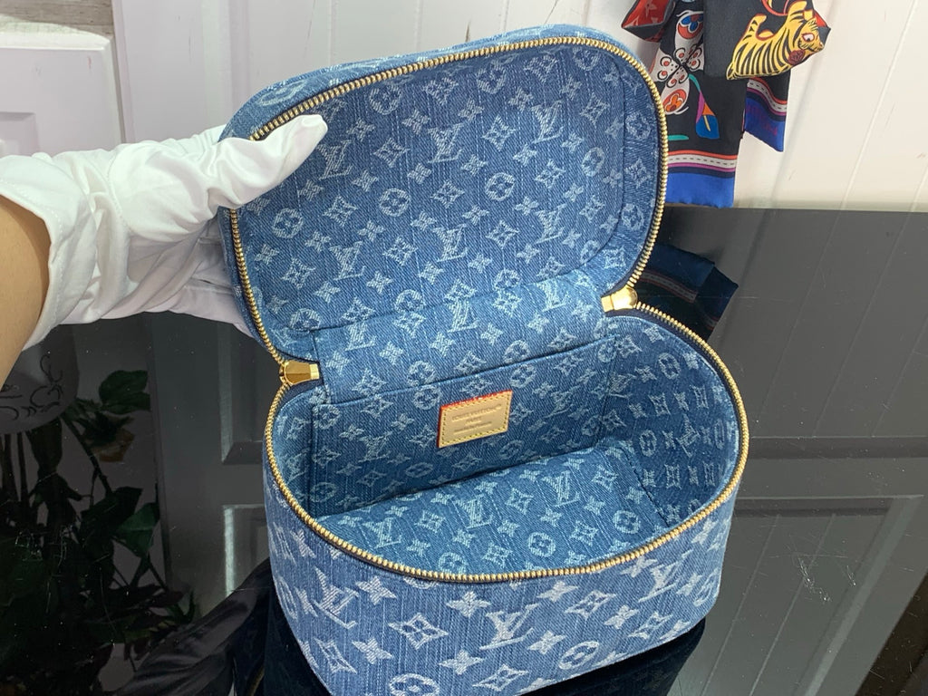 Open blue monogram vanity bag with gold zipper trim and tan interior label.