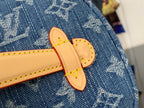 Tan leather sandal-shaped charm on blue monogram bag with yellow stitching.