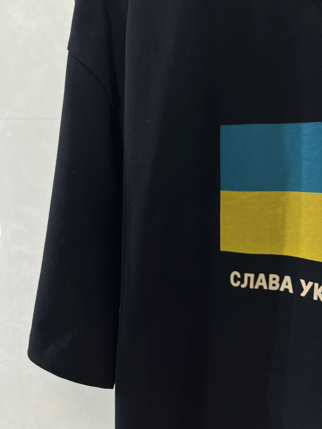 Balenciaga T-shirt side view with blue-yellow flag panel and Cyrillic text