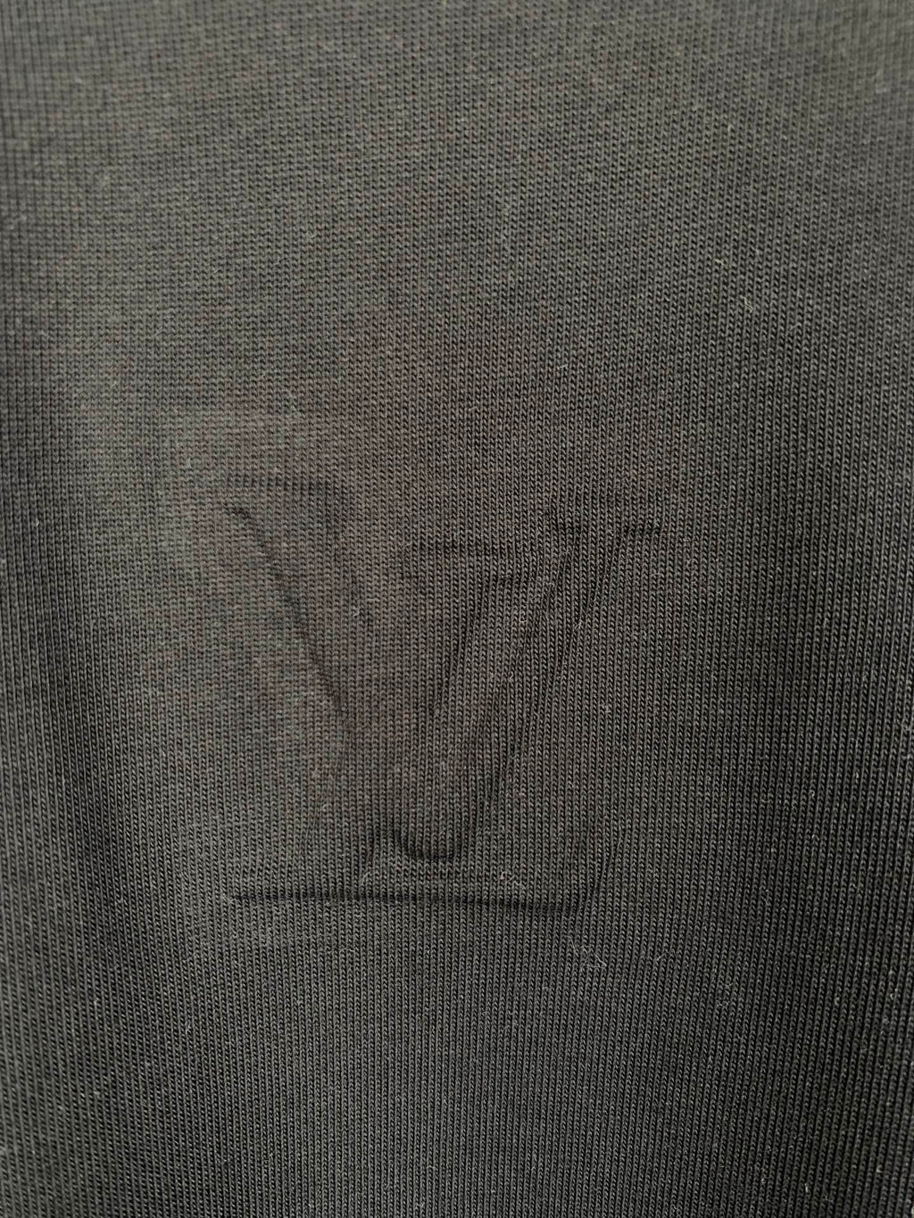 Louis Vuitton T-shirt fabric close-up with embossed LV logo, dark black