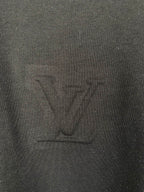 Louis Vuitton T-shirt fabric close-up with embossed LV logo, dark black