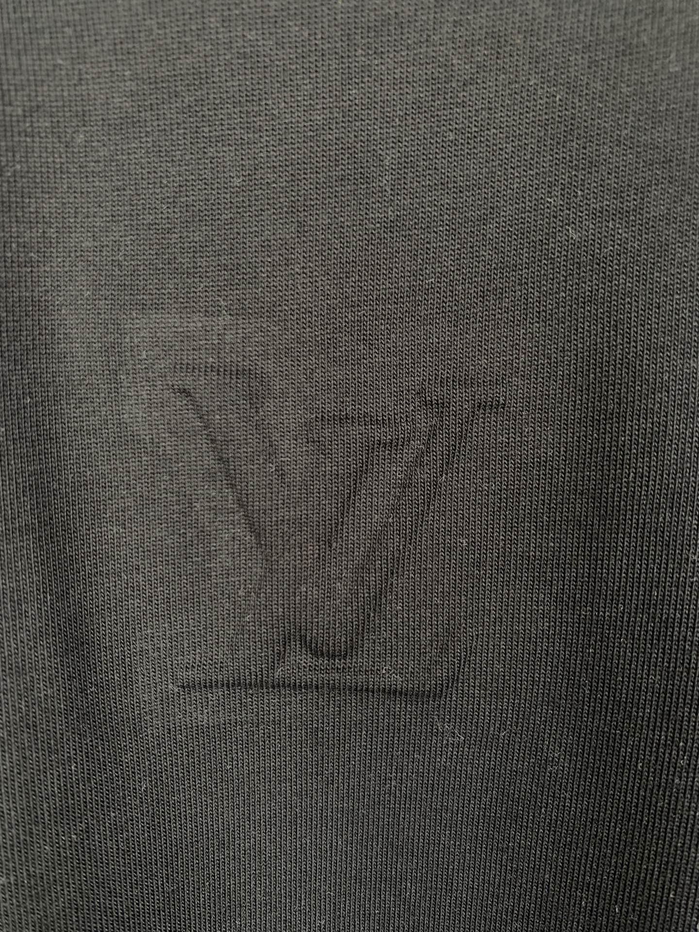 Louis Vuitton T-shirt fabric close-up with embossed LV logo, dark black