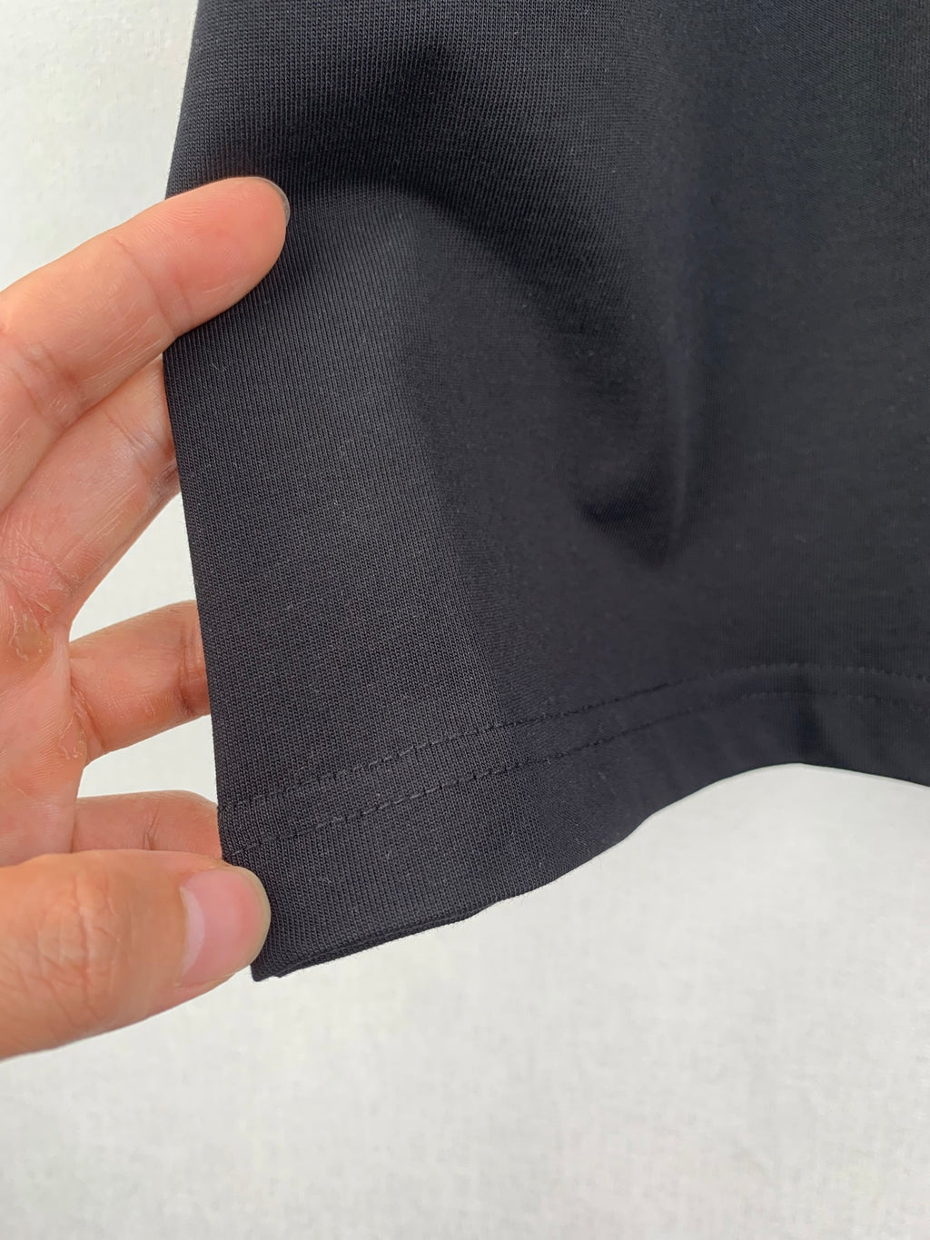Louis Vuitton T-shirt sleeve fabric close-up, dark black with seam stitching