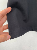 Louis Vuitton T-shirt sleeve fabric close-up, dark black with seam stitching