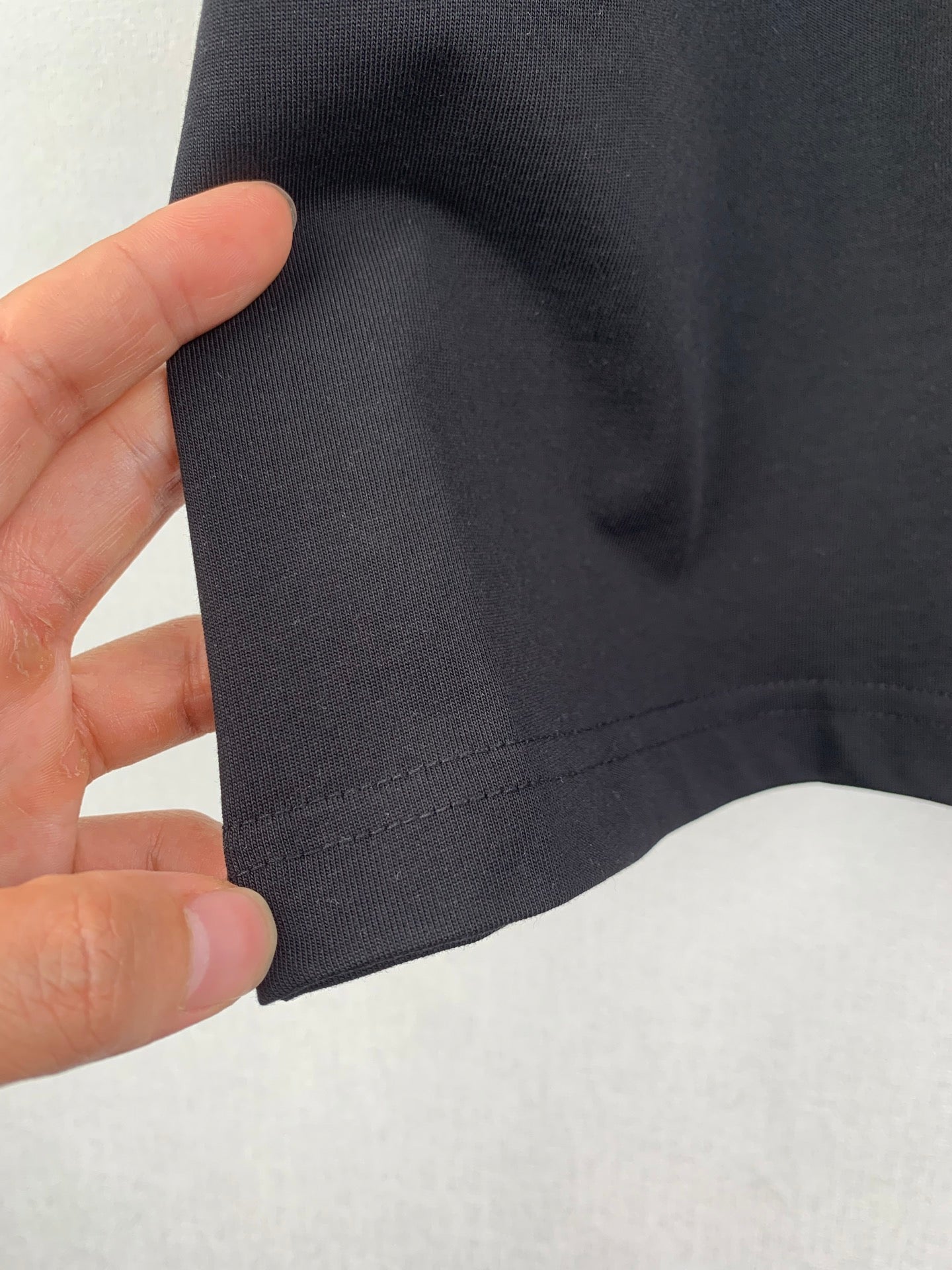 Louis Vuitton T-shirt sleeve fabric close-up, dark black with seam stitching