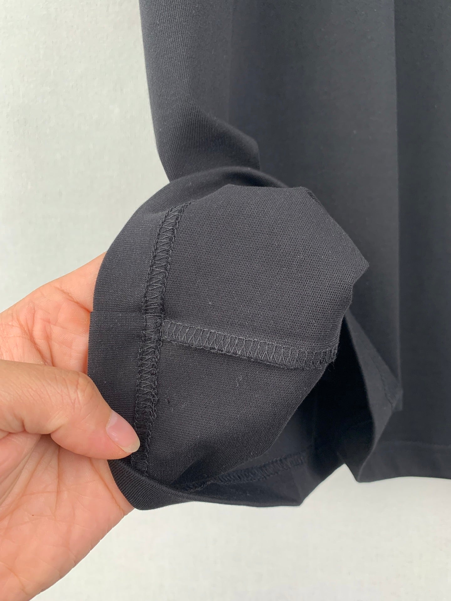 Louis Vuitton T-shirt cuff close-up with double-stitched hem, dark black