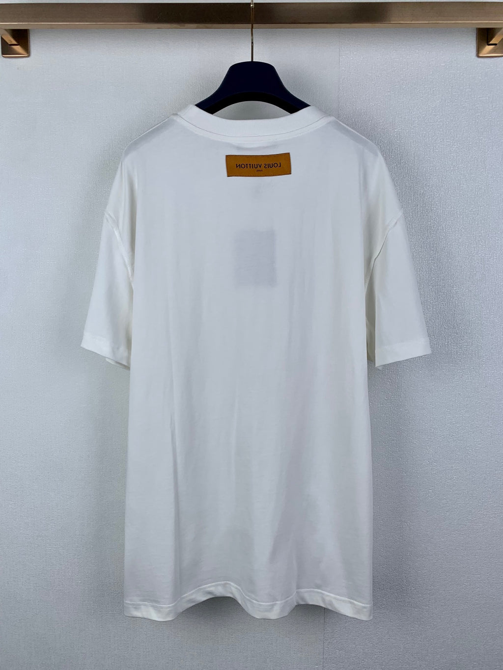 White short-sleeve T-shirt with small rectangular label at upper back.