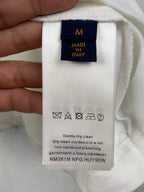 Louis Vuitton clothing care tag with size M and Italy, care instructions printed.
