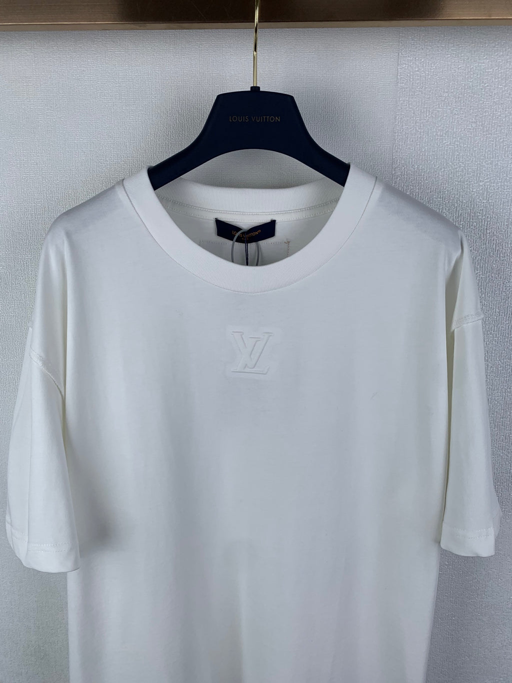 White short-sleeve T-shirt with embossed LV logo at center chest.