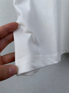 White T-shirt hem with stitched seam detail near side.