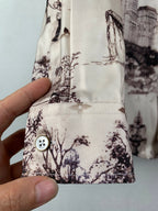 White printed button-up shirt sleeve cuff with round dark logo-style button