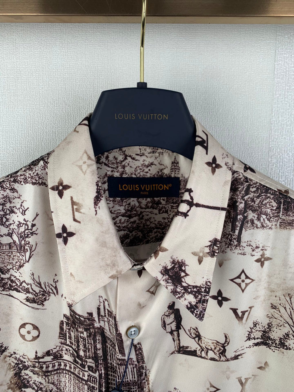 Men's button-up shirt collar and placket, white with dark emblem and city print