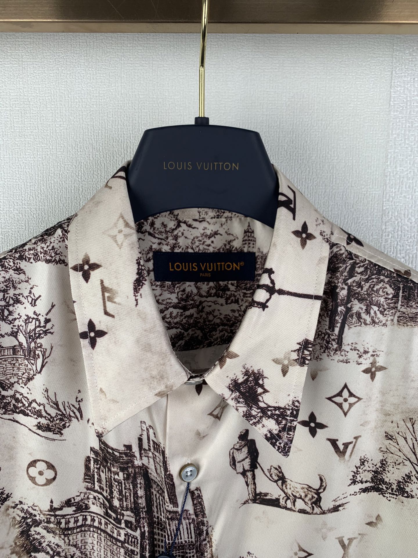 Men's button-up shirt collar and placket, white with dark emblem and city print