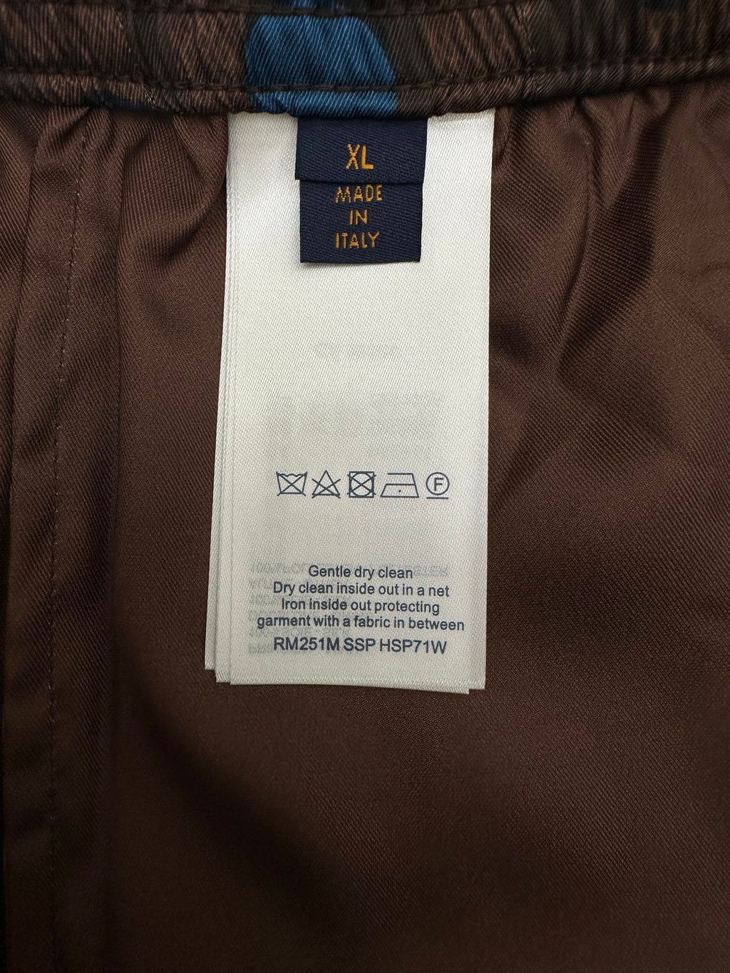 Size XL tag and care symbols on brown shorts