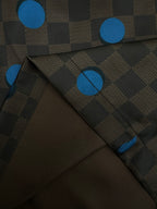 Close-up of brown shorts fabric with blue dot and check pattern