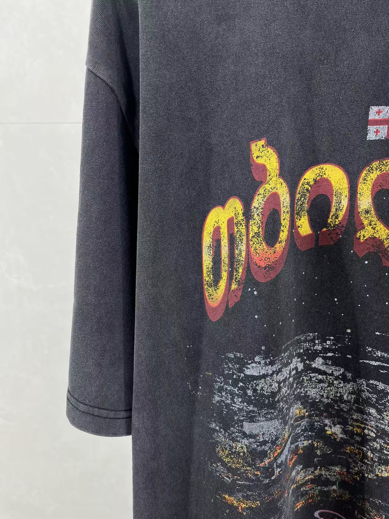 Dark blue T-shirt front with yellow and pink logo graphic and paint splatter