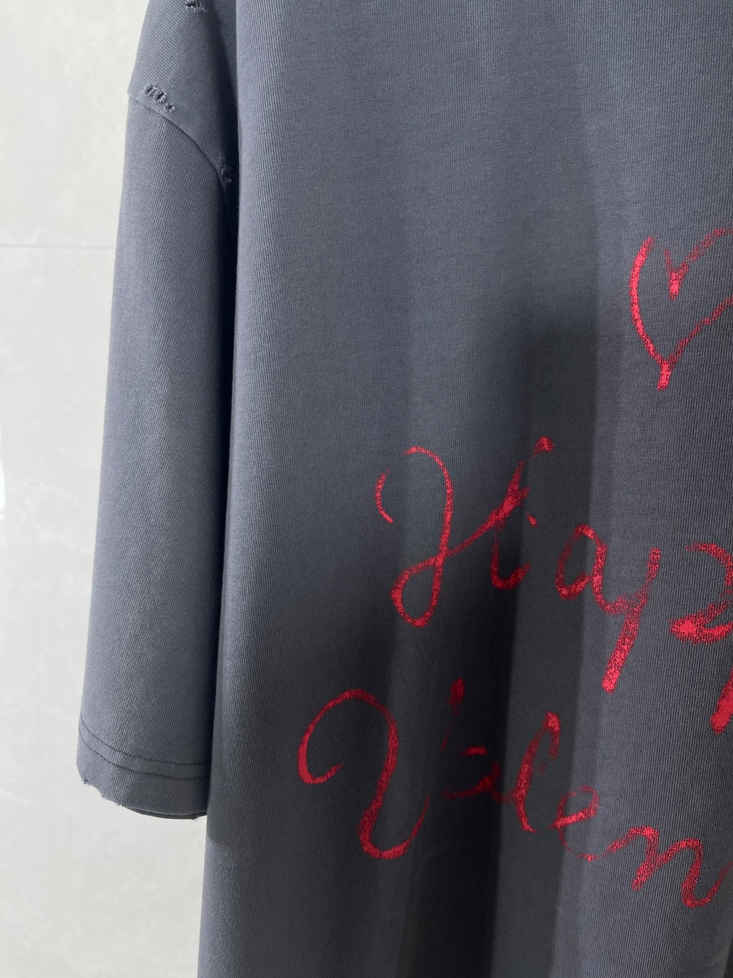 Balenciaga dark navy T-shirt sleeve with red cursive script print, cropped view