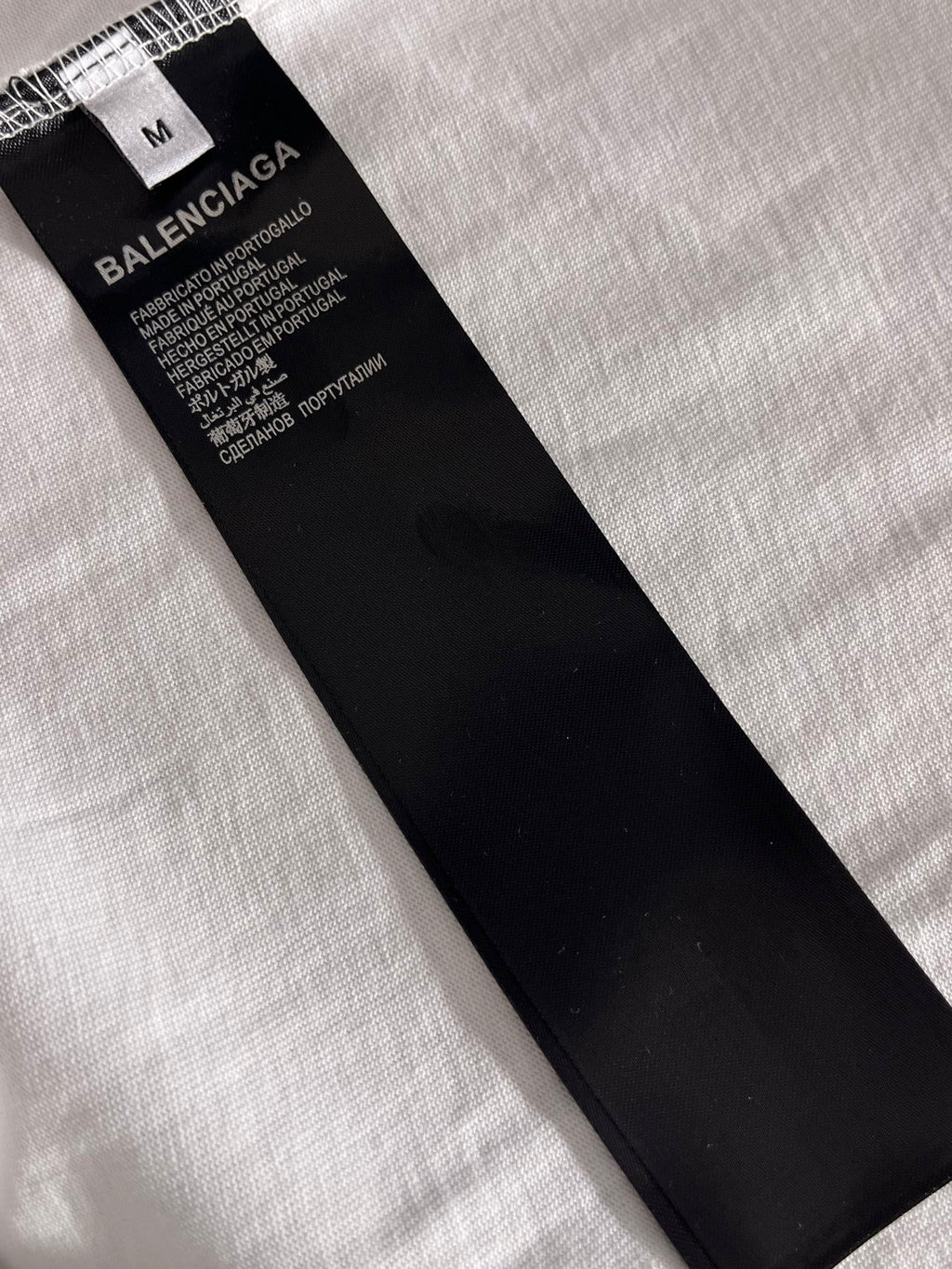 Balenciaga clothing size M tag and care label on black fabric piece