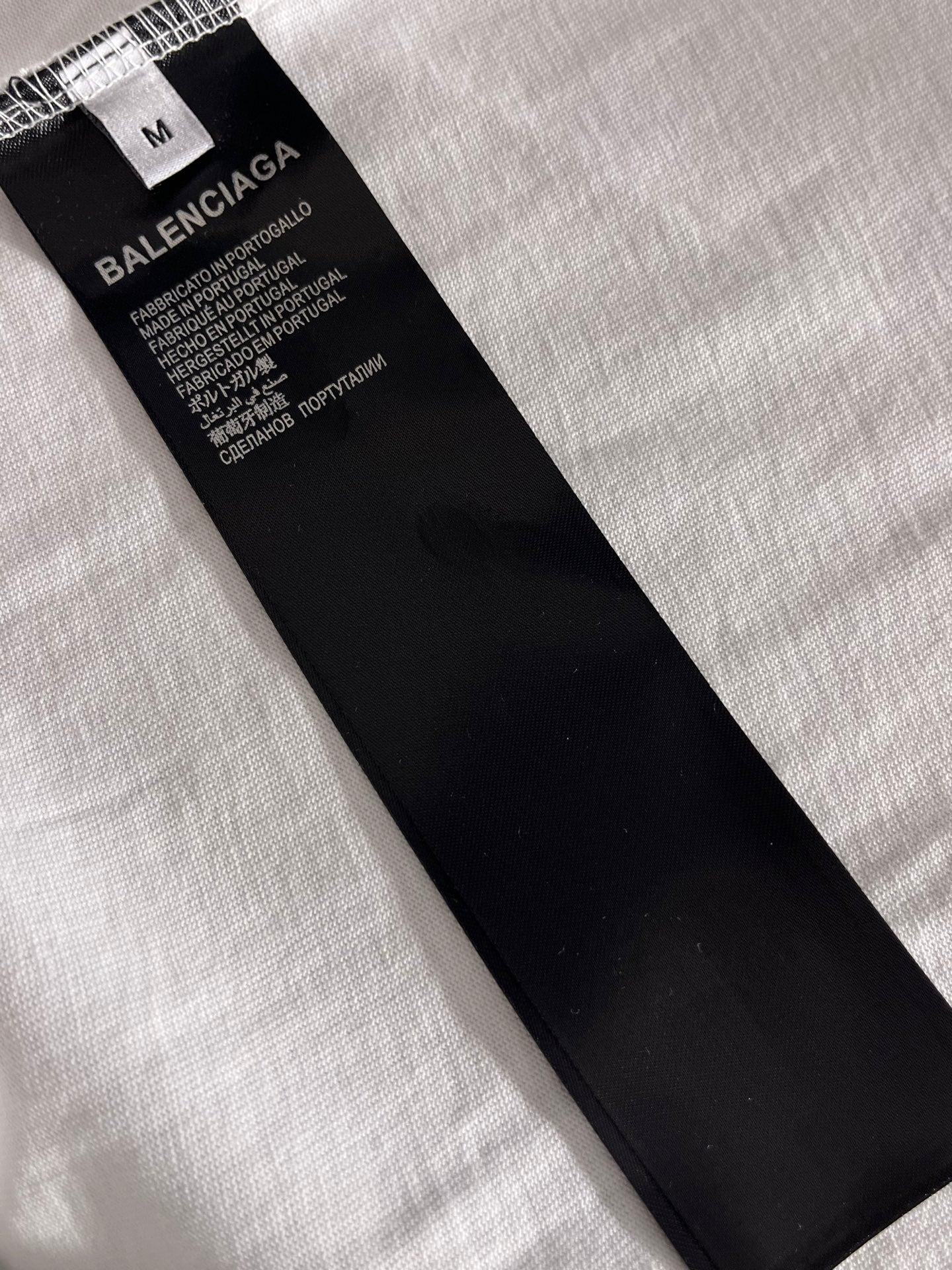 Balenciaga clothing size M tag and care label on black fabric piece