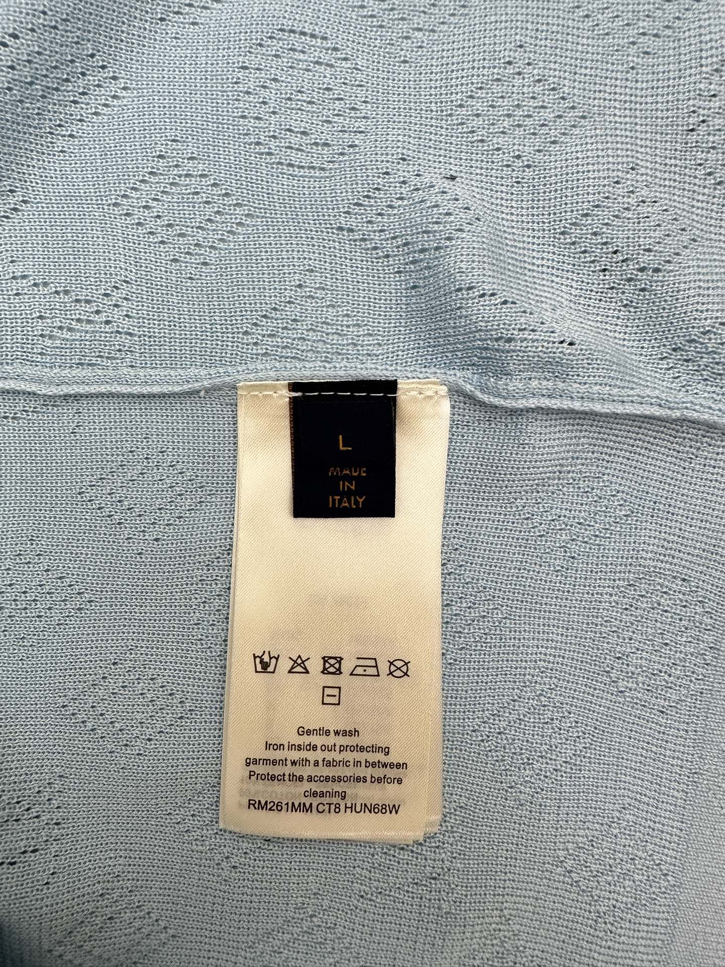 Light blue polo shirt fabric with size and care label