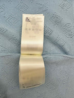 Light blue polo shirt fabric with care instructions label