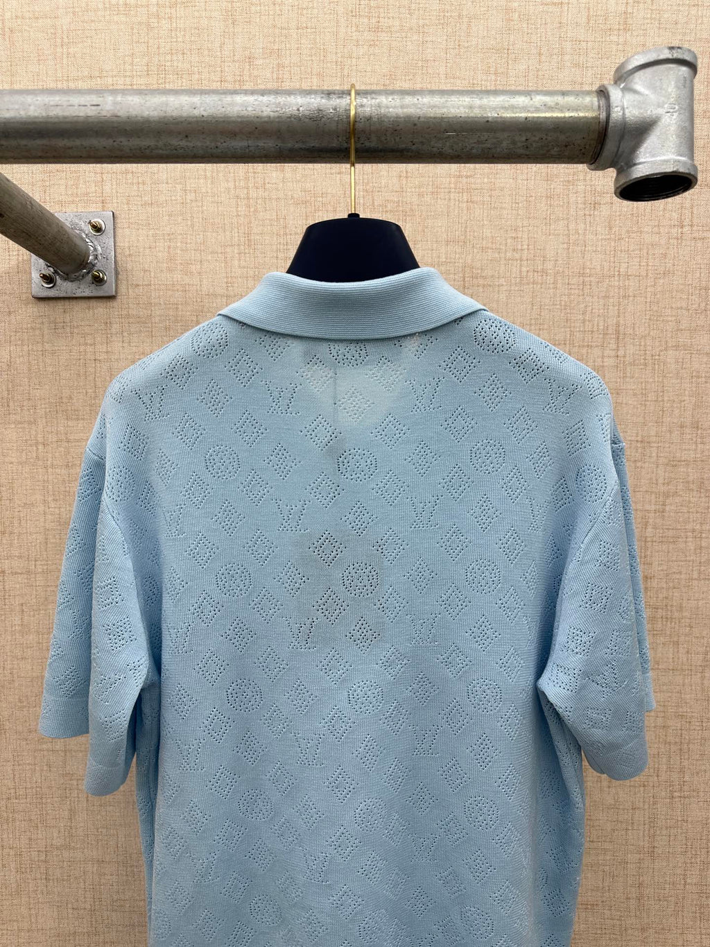 Light blue polo shirt back view with woven logo texture