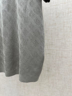 Light gray polo shirt sleeve with repeating monogram knit texture