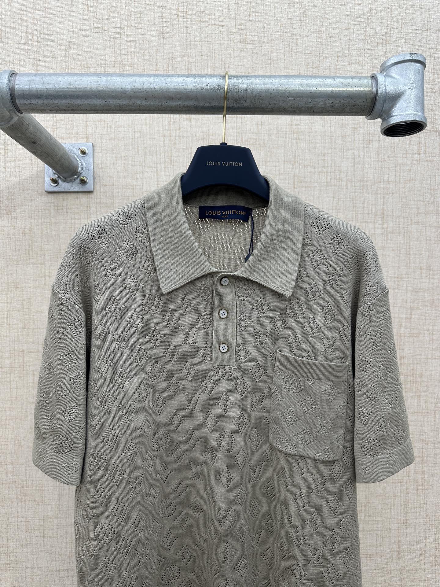 Light gray polo shirt with textured monogram pattern and front pocket