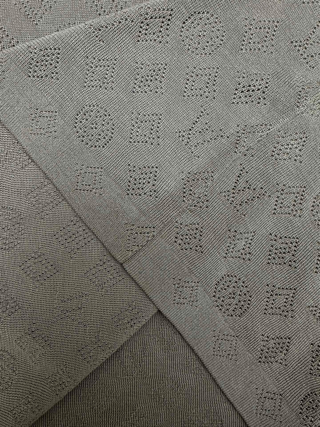 Gray polo fabric close-up showing knit pattern on fold seams