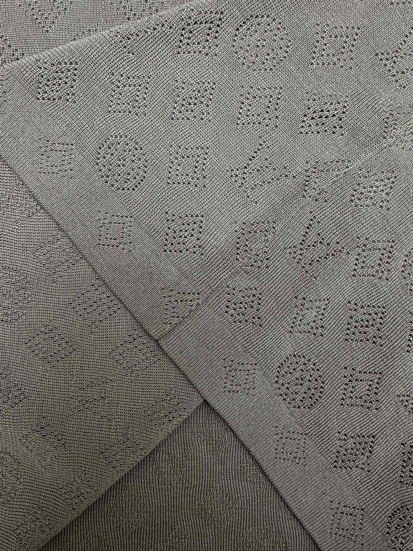 Gray polo fabric close-up showing knit pattern on fold seams