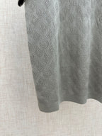 Gray polo fabric close-up with repeating monogram-style pattern