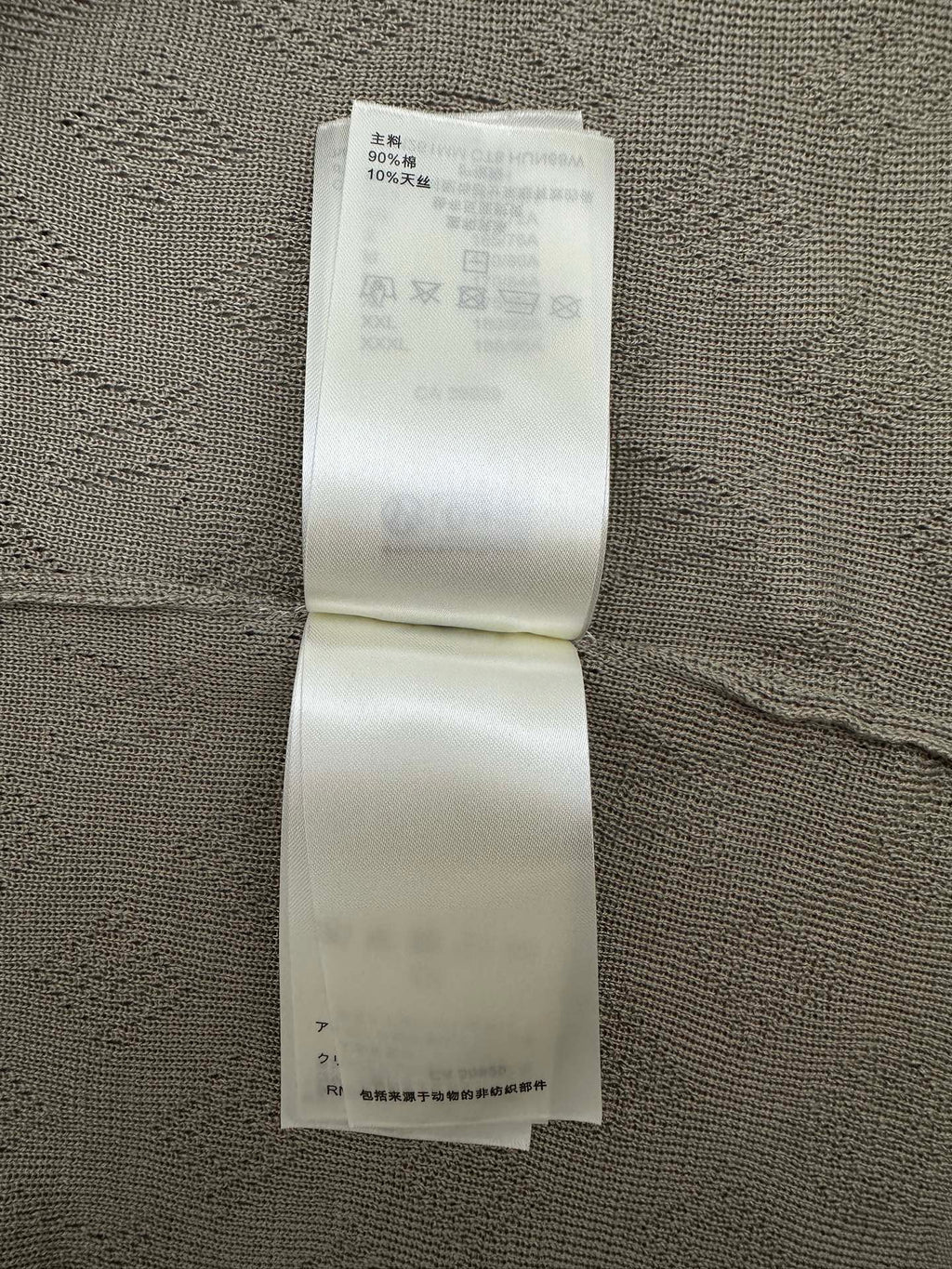 Gray polo care label strip on inside seam with washing instructions
