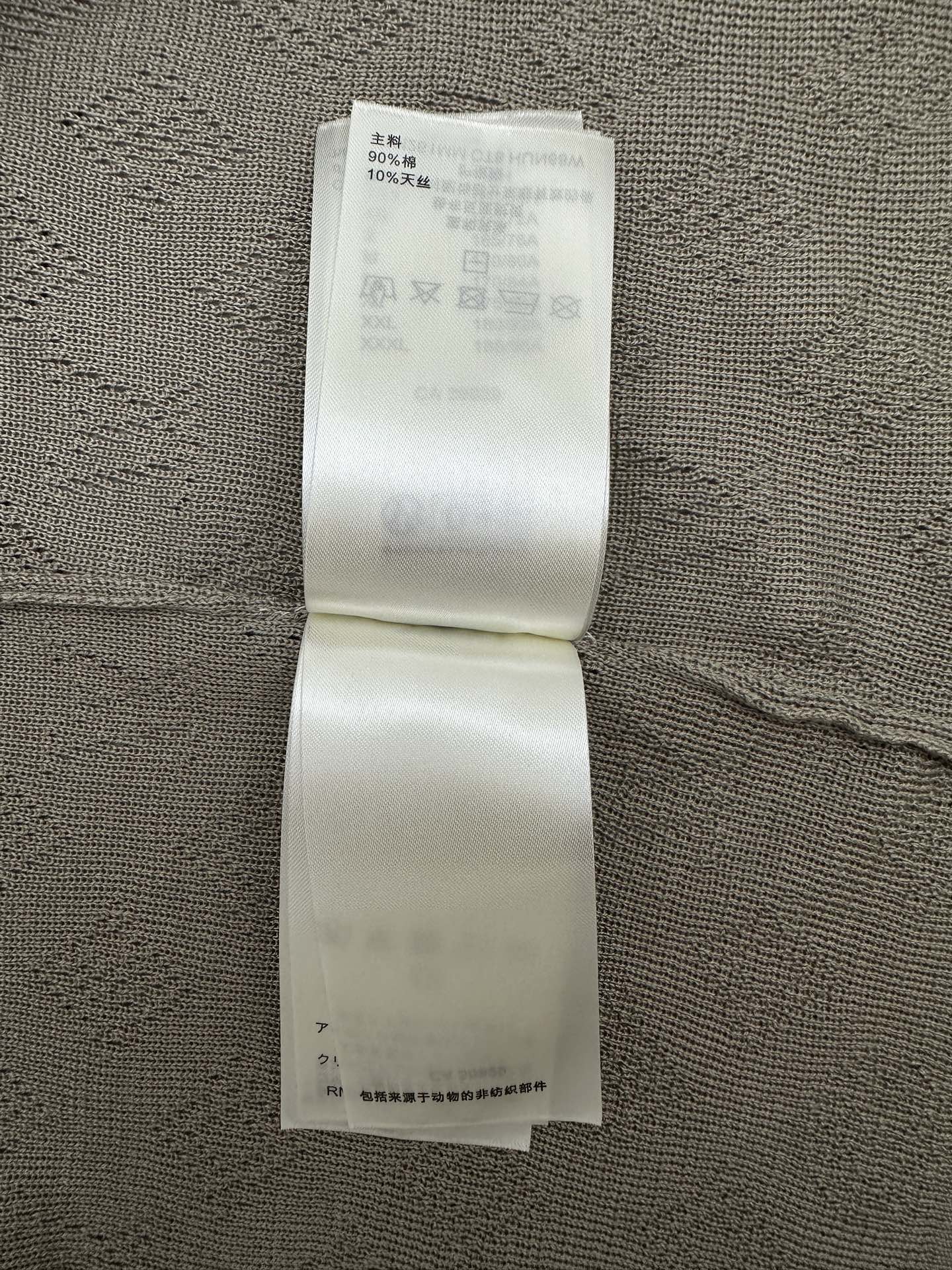Gray polo care label strip on inside seam with washing instructions