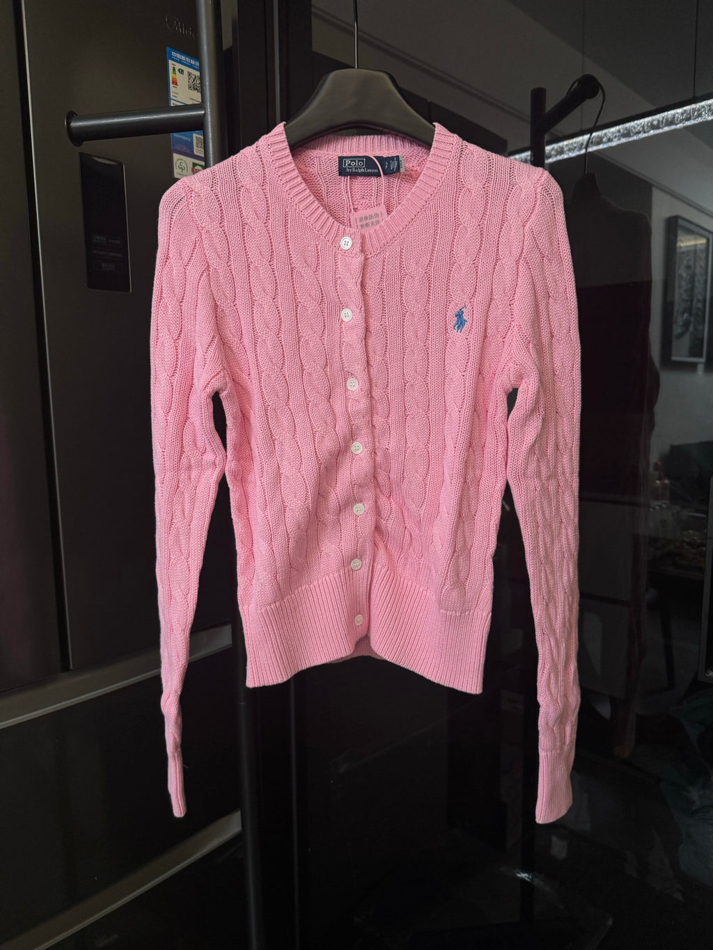 Pink cable-knit cardigan sweater with button front and small Polo logo on chest.