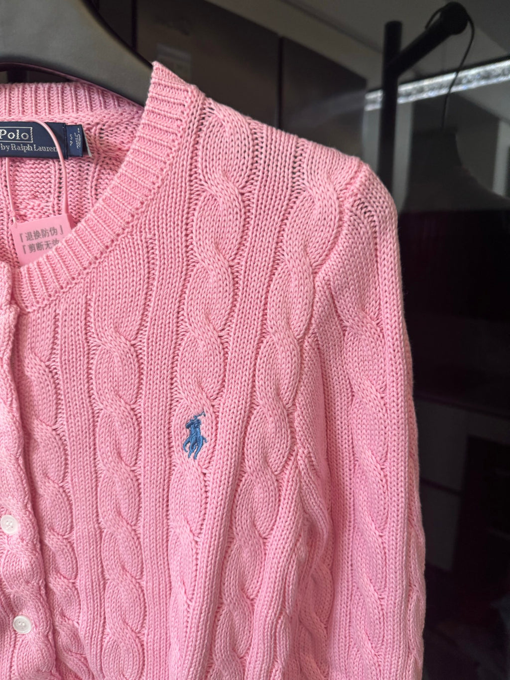 Pink cable-knit sweater with Polo logo at chest, long sleeves, button placket.