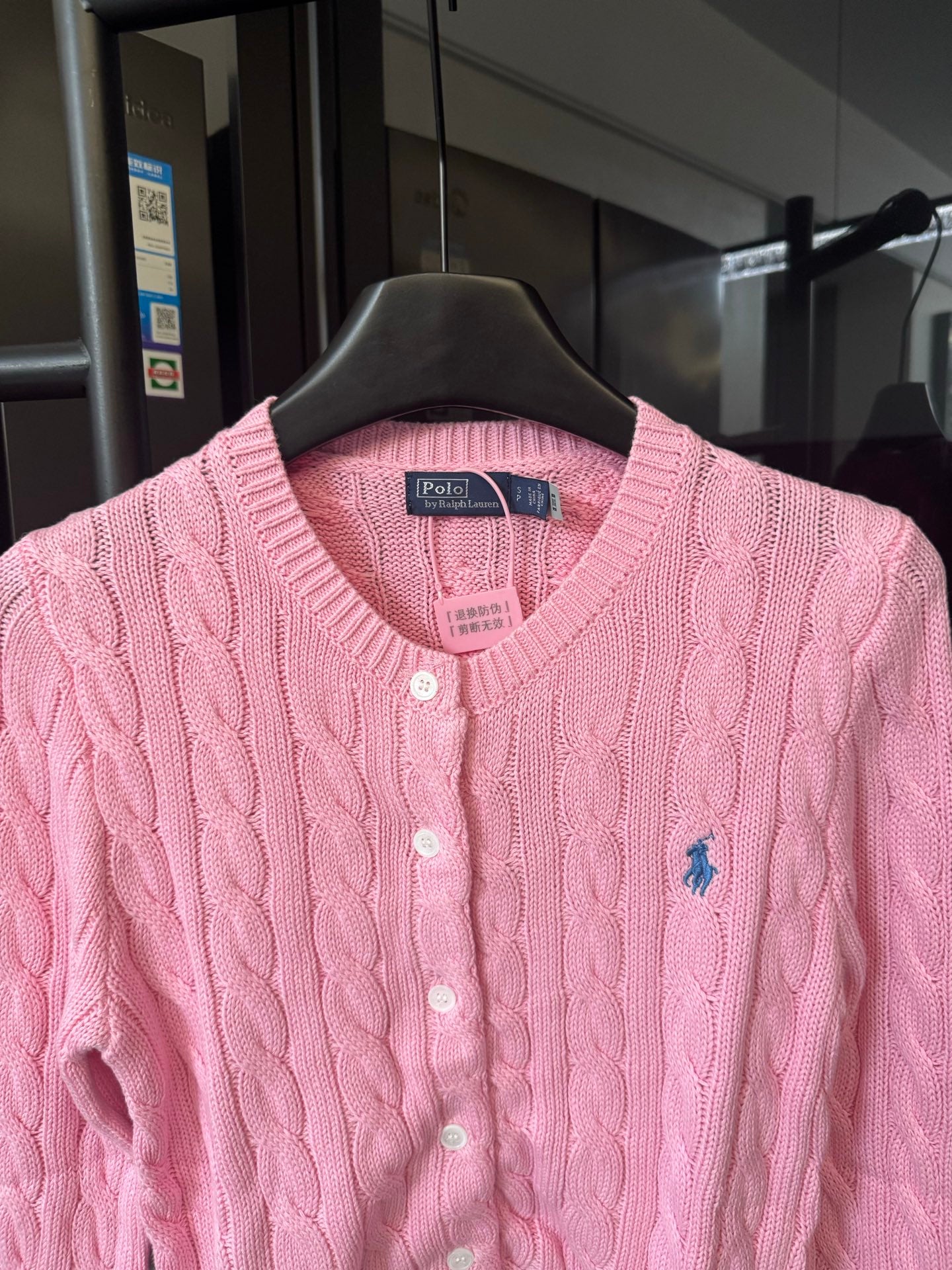 Pink cable-knit cardigan with V-neck, button front, and Polo logo patch at chest.