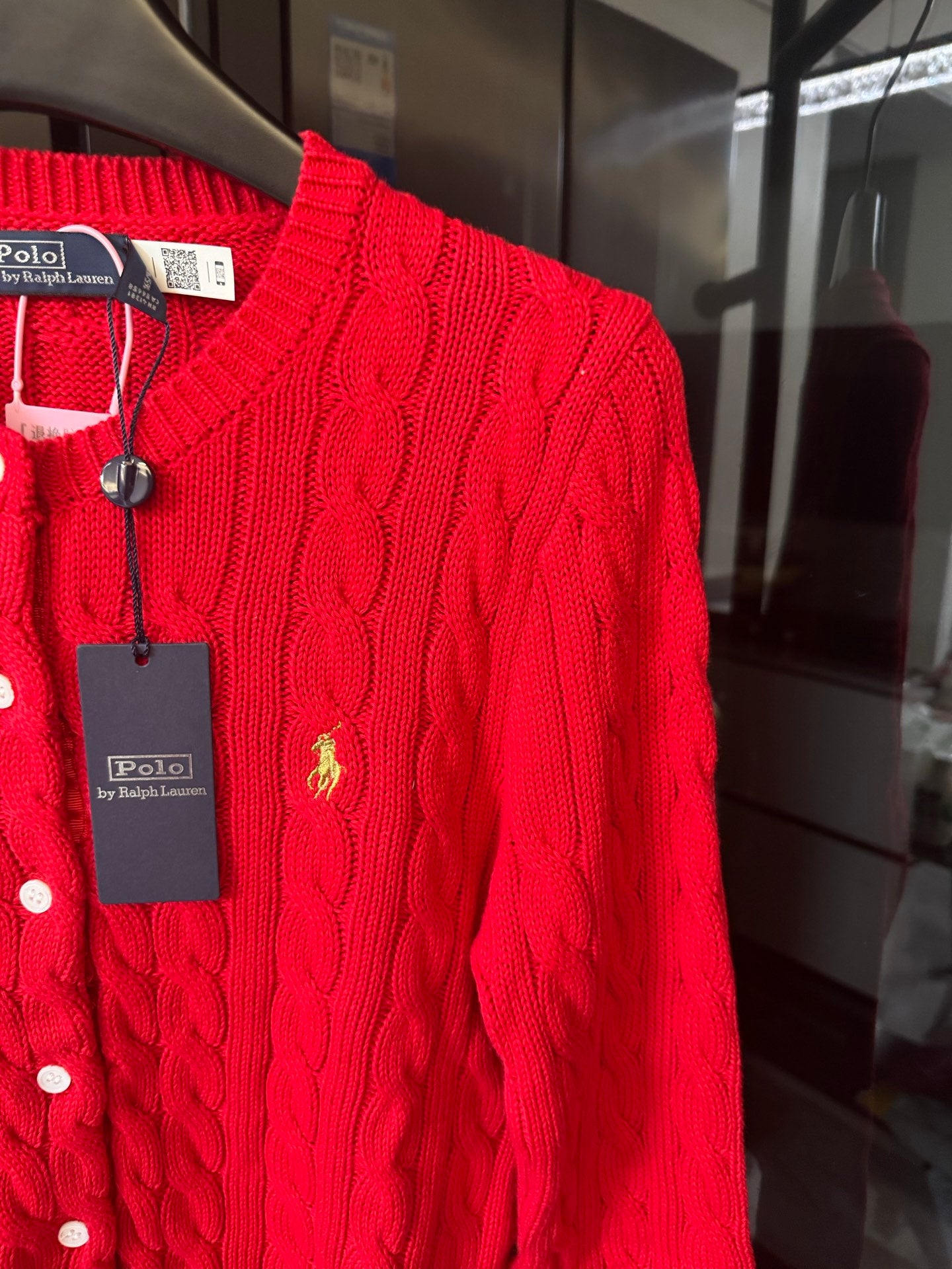 Ralph Lauren cable-knit cardigan, red, close-up of polo crest on buttoned placket