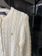Ivory cable-knit sweater close-up, cable pattern and small pony logo