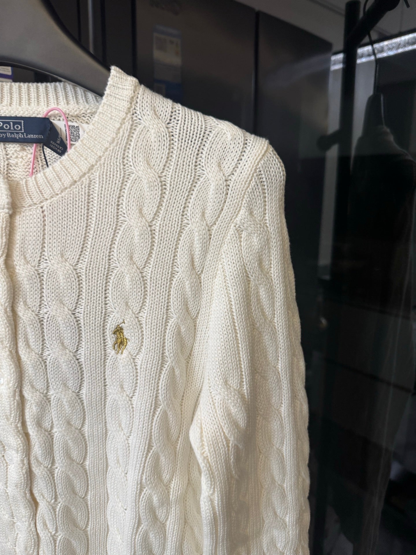 Ivory cable-knit sweater close-up, cable pattern and small pony logo