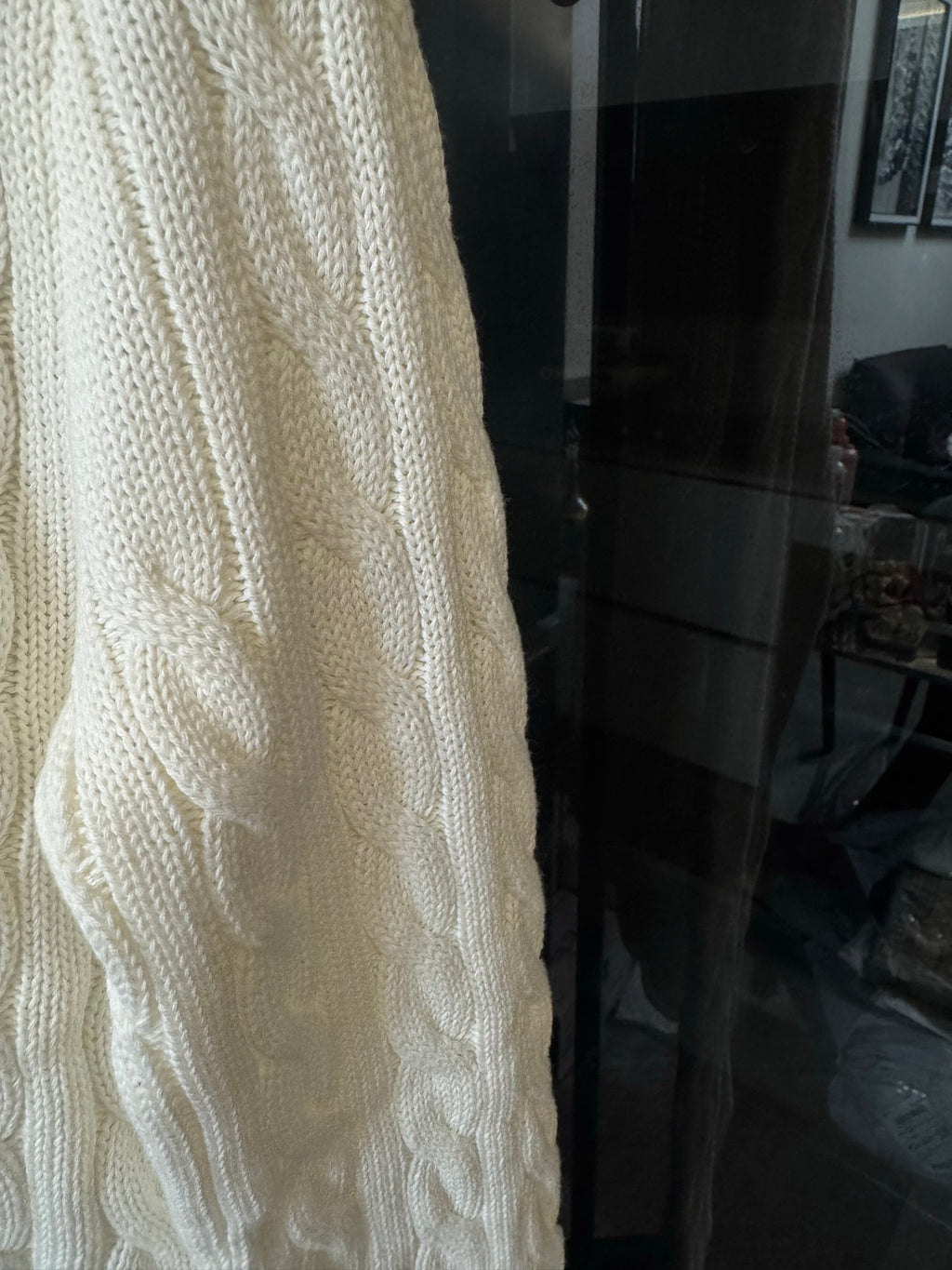 Ivory cable-knit sweater side panel with textured cable pattern