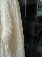 Ivory cable-knit sweater side panel with textured cable pattern