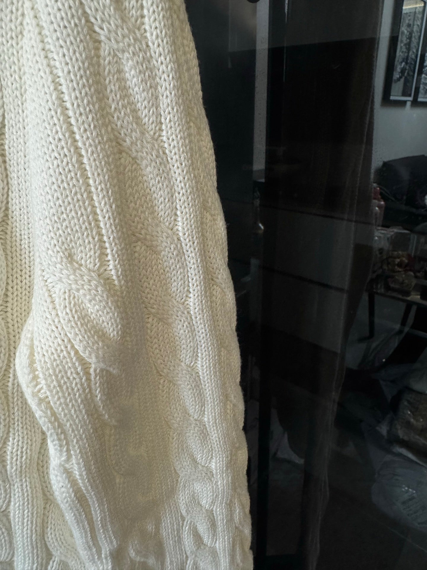 Ivory cable-knit sweater side panel with textured cable pattern