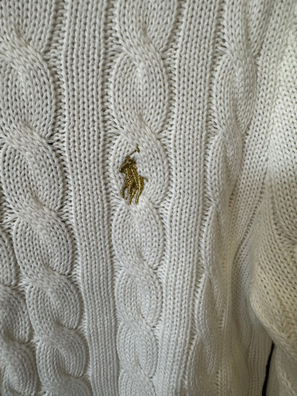Ivory cable-knit sweater with small gold pony logo on textured knit