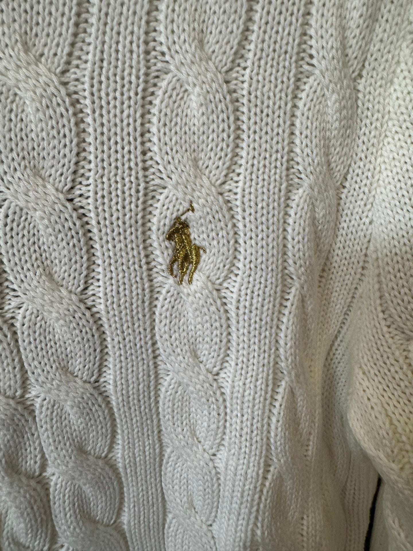 Ivory cable-knit sweater with small gold pony logo on textured knit