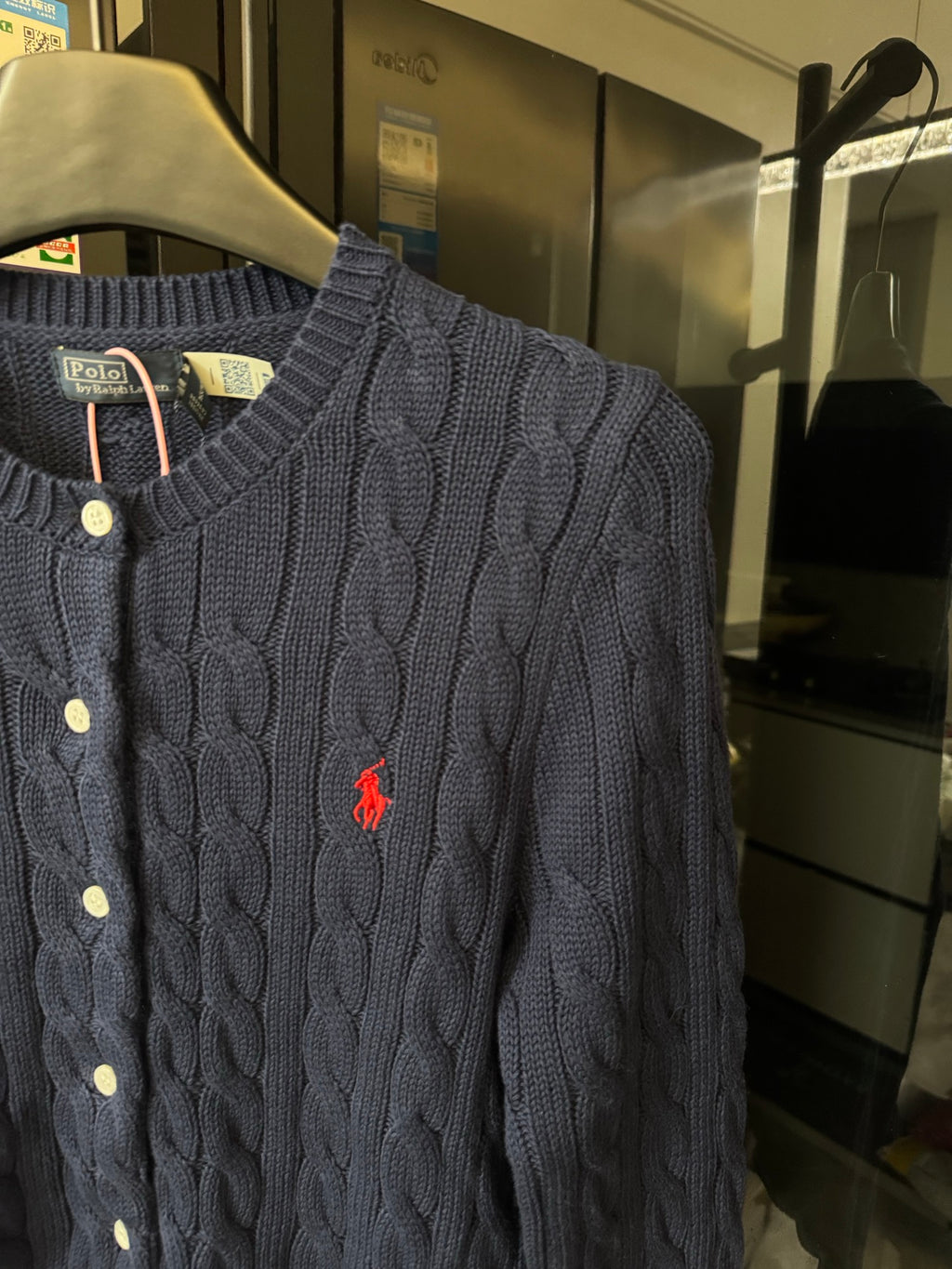 Dark gray cable-knit cardigan with red polo logo, button placket detail